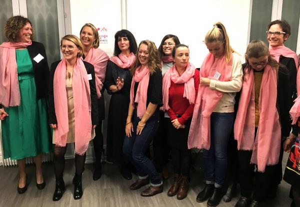 Photographie de l'équipe de la Maison des Femmes portant des écharpes roses