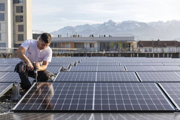 Un artisan installe des panneaux solaires