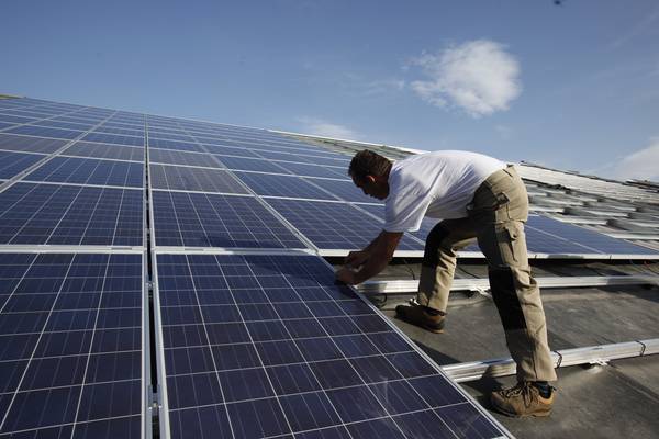 Un ouvrier pose des panneaux photovoltaiques