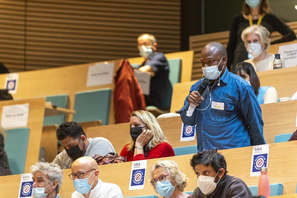 Un citoyen prend la parole au sein de l'amphithéâtre dans lequel tous les participants sont réunis. 